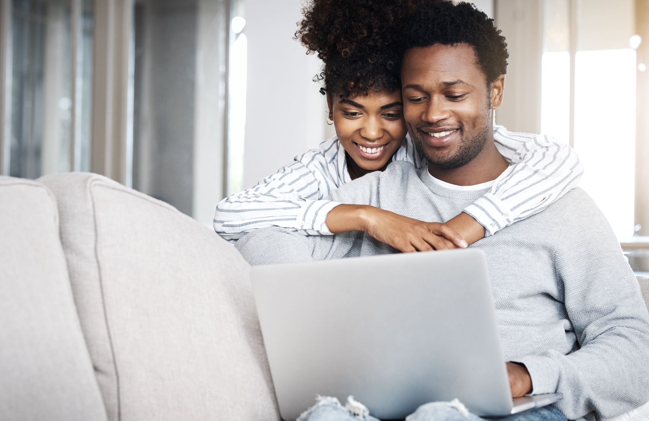 Couple on couch looking at laptop